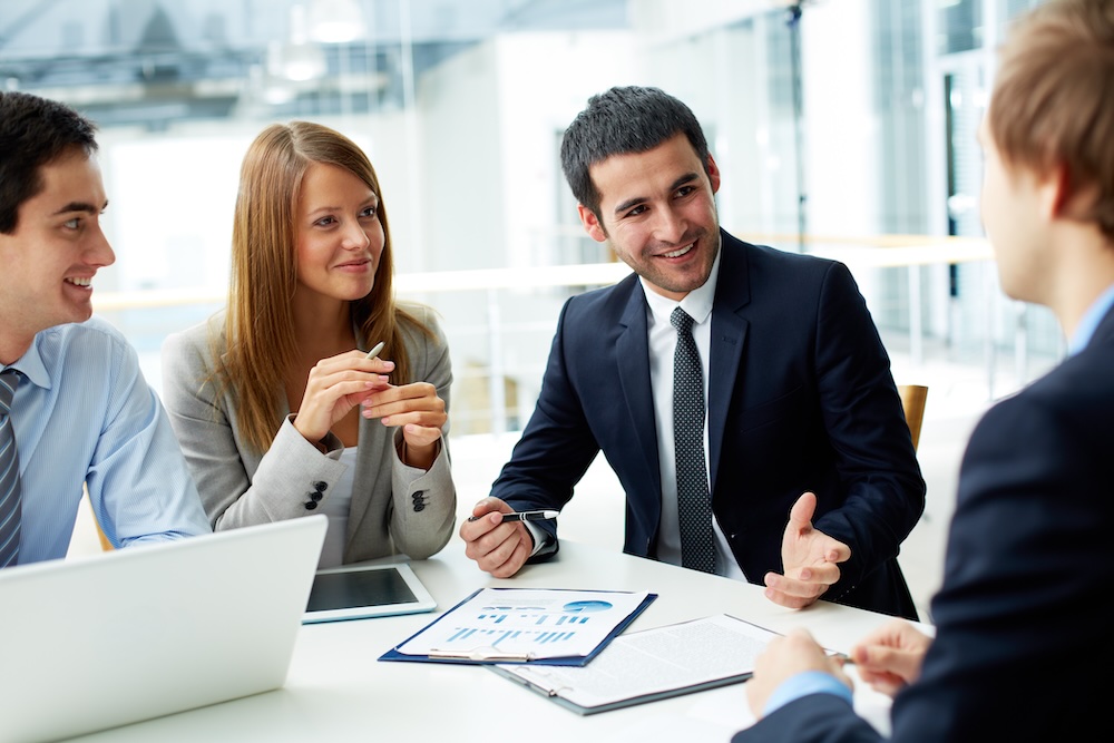 4 office workers around desk